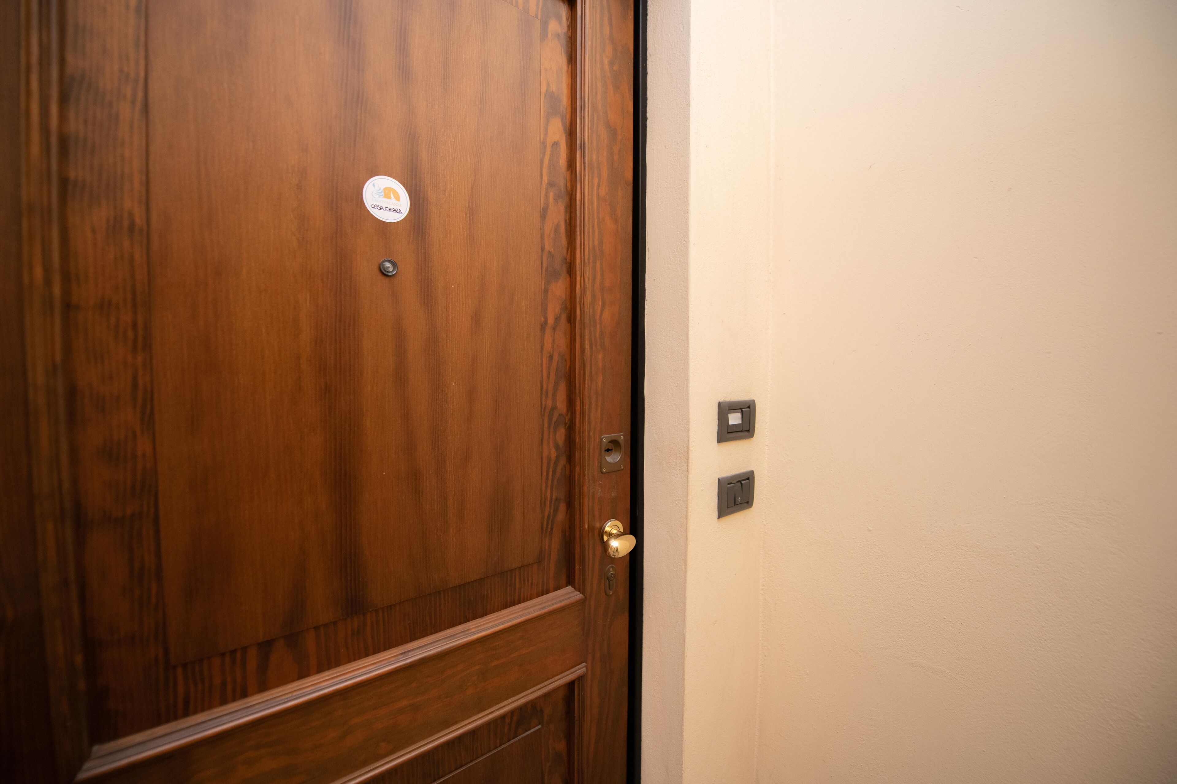 Une porte en bois avec une poignée de porte en laiton et un autocollant.