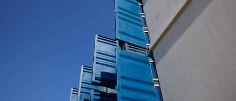 A modern building with a series of blue glass panels and metal frames.