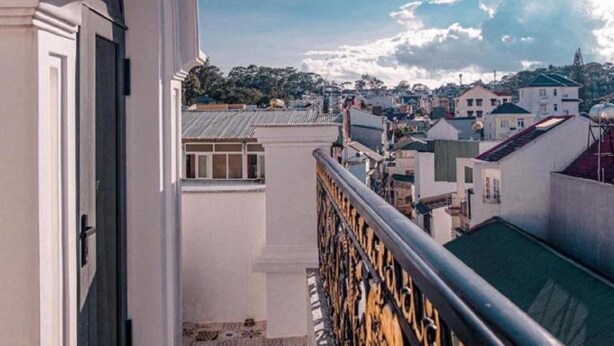 Un balcón con vista a un paisaje urbano, con edificios y cielo despejado.