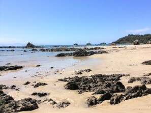 A beach with rocky terrain and clear blue water.