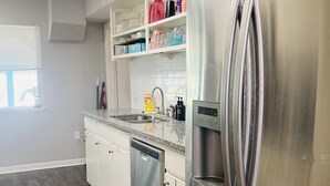 A modern kitchen with stainless steel appliances, white cabinetry, and a wooden floor. - Spacious 3BR Brick Home, Sleeps 7❤️Free Parking❤️No Pet Fee❤️No Extra Guest Fee🏖️ (Texas City)