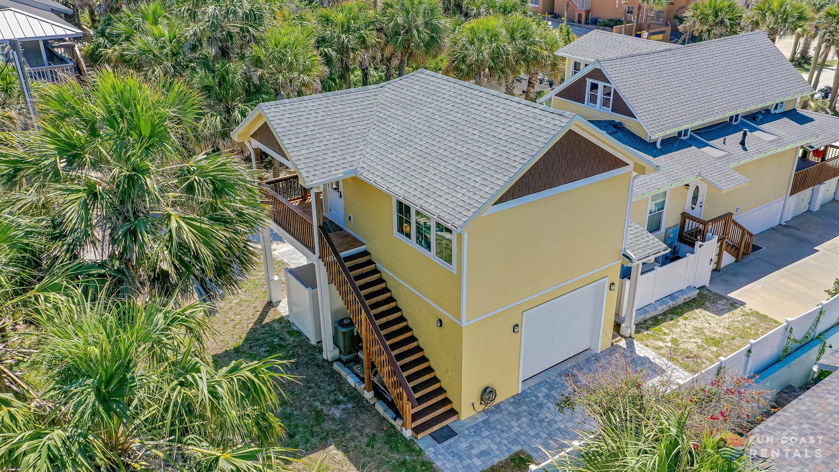 A two-story house with a balcony, a garage, and a swimming pool.