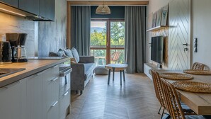 A modern kitchen with a dining area, large windows, and a view of the outdoors. - RentPlanet - Green Park Resort (Szklarska Poreba)