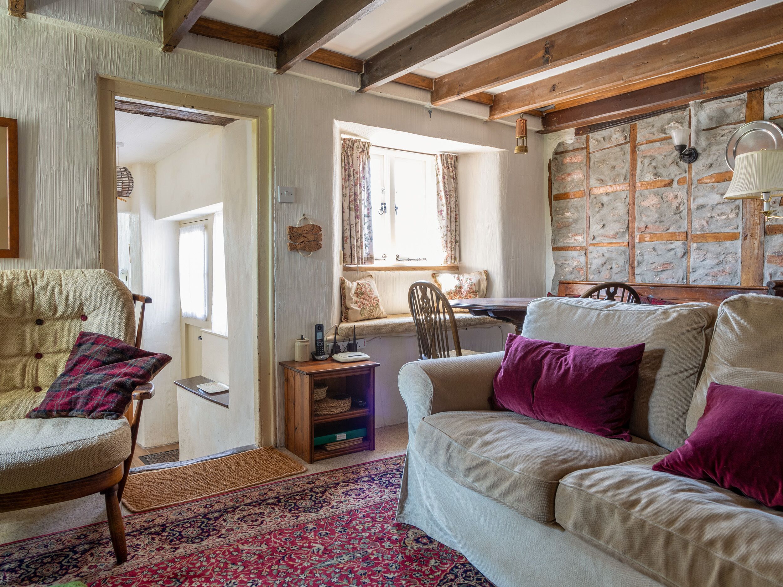 A cozy living room with a sofa, armchairs, a wooden coffee table, and a patterned rug.