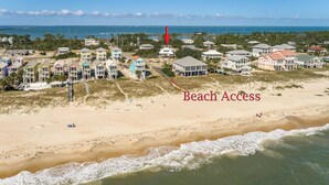 A coastal area with beach access, houses, and a lighthouse.
