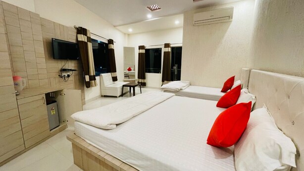 Une chambre d’hôtel avec deux lits, une télévision, un bureau et une salle de bain.