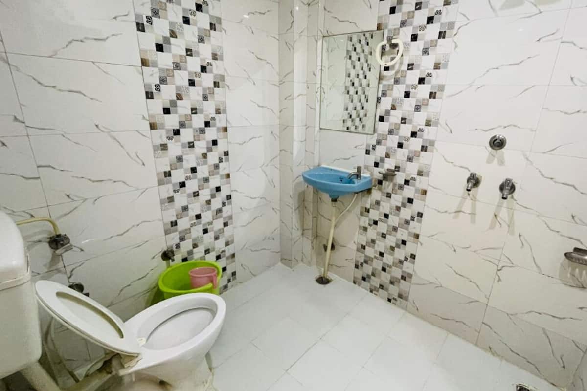Un baño con inodoro, lavamanos y zona de ducha.