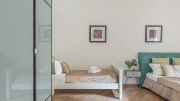 Une chambre moderne avec un lit simple, une table de chevet et une commode. Deux tableaux encadrés ornent le mur.