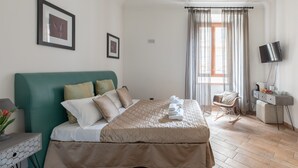 A neatly arranged bedroom with a bed, a desk, a chair, and a TV. - Flaminiarooms (Rome)
