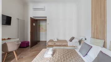 Une chambre d’hôtel comprenant un lit, un bureau, une chaise, une télévision et une salle de bain.