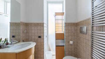 Une salle de bain équipée d’un lavabo, de toilettes et d’une douche à parois en verre.