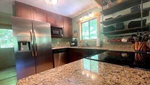 A kitchen with granite countertops, stainless steel appliances, and wooden cabinets. - Bear's Den Max - 4 bedrooms in the Nantahala Gorge - free rafting or other (Bryson City)