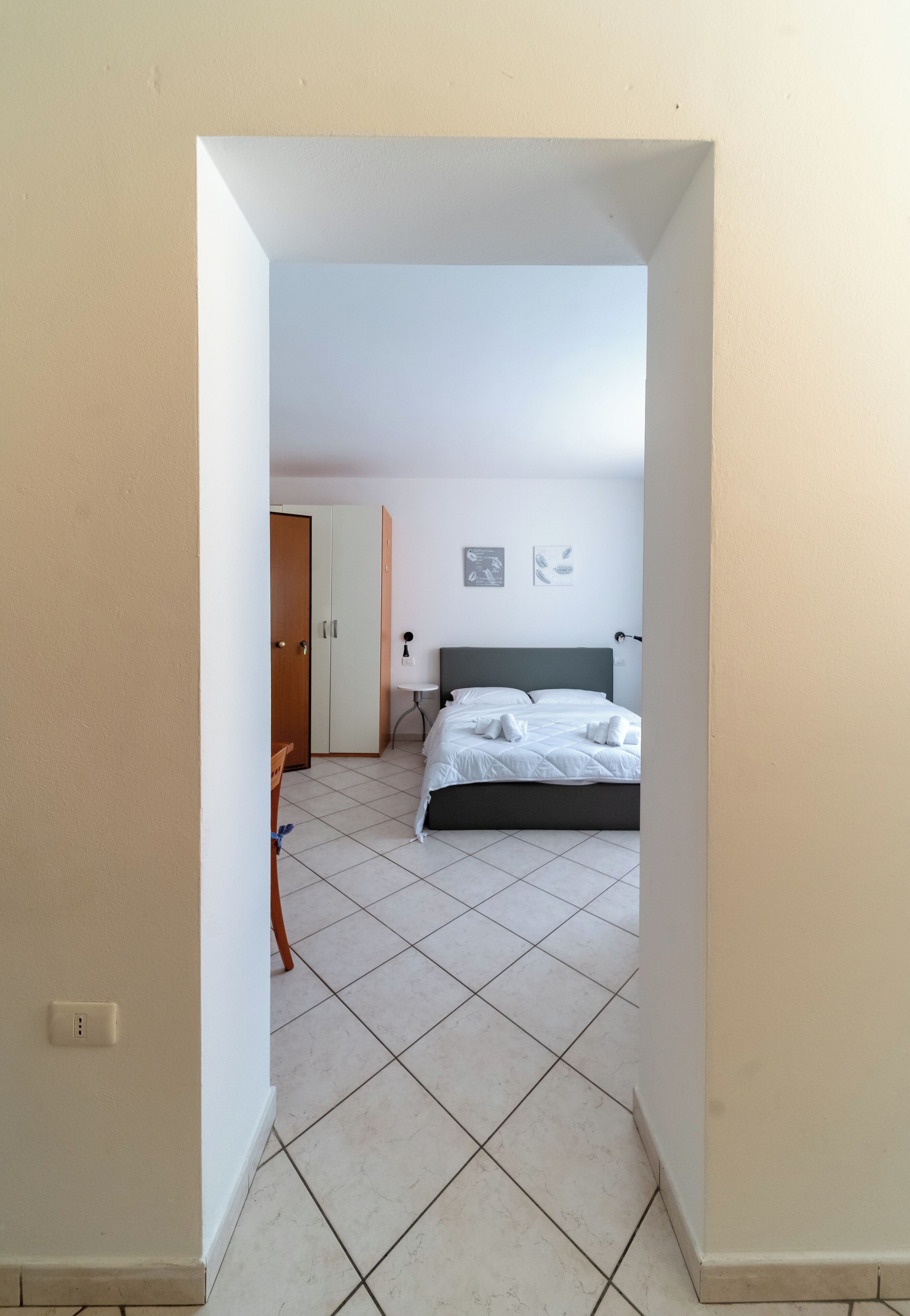 A hotel room with a bed, a desk, and a chair.