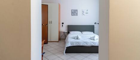 Una habitación de hotel con una cama, un escritorio y una silla.