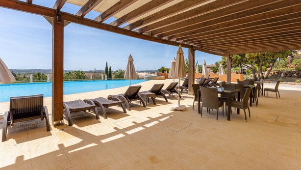 A covered outdoor area with lounge chairs and umbrellas, a pool, and a view of the landscape. - Casa Serenidade - Vale de Ribeira (Arão (Mexilhoeira Grande))