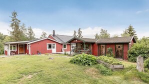A red wooden house with a porch, a front yard, and a small garden. - Experience the Ultimate in Comfort and Serenity (Stockholms län)