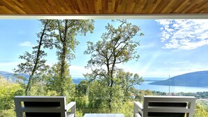A deck with two white chairs and a small table, overlooking a scenic view of trees and a body of water. - 5 Luxury Contemporary Villa With Pool & Seaview - Lavender Boka Hill -brand new (Podi)