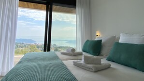 A hotel room with a bed, a view of the sea, and a cityscape. - 5 Luxury Contemporary Villa With Pool & Seaview - Lavender Boka Hill -brand new (Podi)