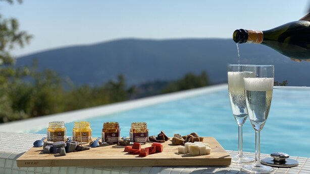 A poolside setting with a wooden board holding cheese and crackers, two glasses of champagne, and a bottle being poured. - 5 Luxury Contemporary Villa With Pool & Seaview - Lavender Boka Hill -brand new (Podi)