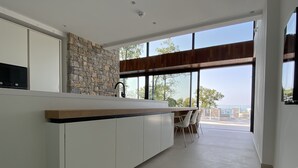 A modern kitchen with a stone backsplash, a wooden countertop, and a view of the outdoors. - 5 Luxury Contemporary Villa With Pool & Seaview - Lavender Boka Hill -brand new (Podi)