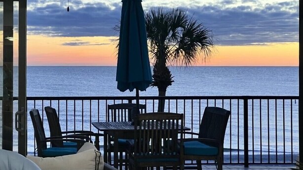A covered outdoor seating area with a view of the ocean at sunset. - NEW! Luxuriously Updated & Renovated Beachfront Retreat- Walkable to Fun!! (Madeira Beach)