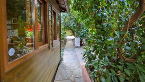 A stone pathway leading to a wooden building with large windows and a signboard. - Çıralı Orange Motel (Kemer)