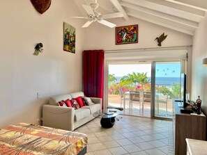 Enjoy ocean views from the balcony, featuring a sofa, table, and artwork.