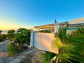 Enjoy a serene escape amidst lush gardens and a scenic view of the sea and distant hills.