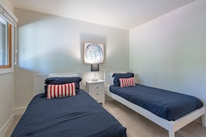 A bedroom with two single beds, a nightstand with a lamp, and a framed artwork on the wall. - Creekside Condo 1335 - Ready for Sun Valley?! New Renovations w/ Resort Pool (Sun Valley)