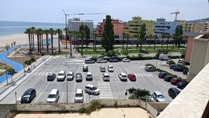 A parking lot with multiple cars, a pedestrian crossing, and a beach in the background. - Seafront Apartment for Rent 6 Sleeps Skyscraper (Fermo)