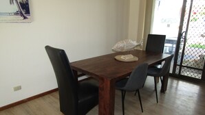 Un coin repas comprenant une table en bois, quatre chaises et une sculpture décorative représentant un poisson.