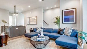 A modern living room with a sofa, coffee table, and artwork on the wall.