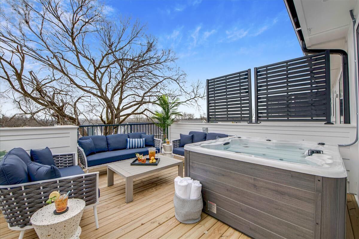Une terrasse extérieure avec un jacuzzi, un espace salon et une vue sur le ciel.