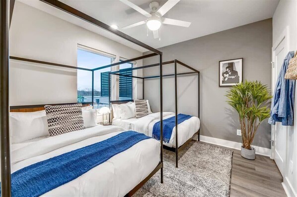 Relax in a serene space with a four-poster bed, ceiling fan, and a view of the outdoors.