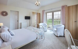 Relax in this cozy space with a large bed, TV, and comfortable seating area.