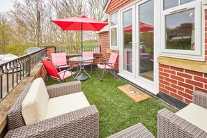 Relax in an outdoor space with a wicker sofa, table, and chairs.