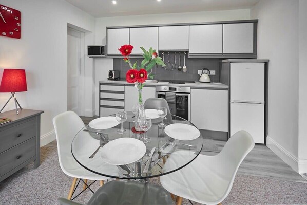 A modern kitchen with white cabinets, a built-in oven, and a refrigerator.