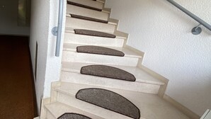 Una escalera con barandilla y pared con textura.