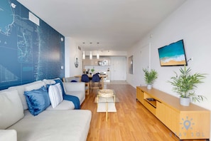 A modern living room with a sofa, a coffee table, a TV, and a wall with a map.