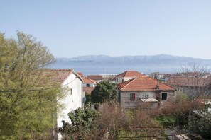 A coastal town with traditional buildings and a clear view of the sea and mountains in the distance. - Apartment Villa DD - Four Bedroom Apartment With Terrace Sea View (Supetar)