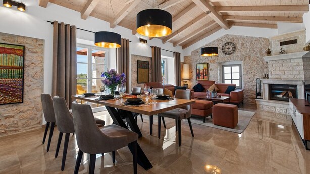 Une salle à manger spacieuse avec une grande table, de nombreuses chaises et une cheminée.