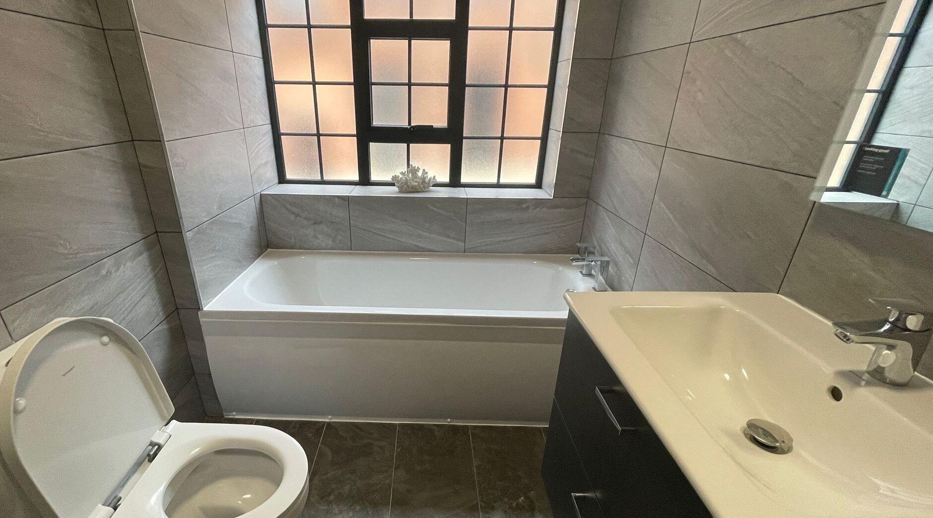 Ein Badezimmer mit Badewanne, Toilette und Waschbecken.