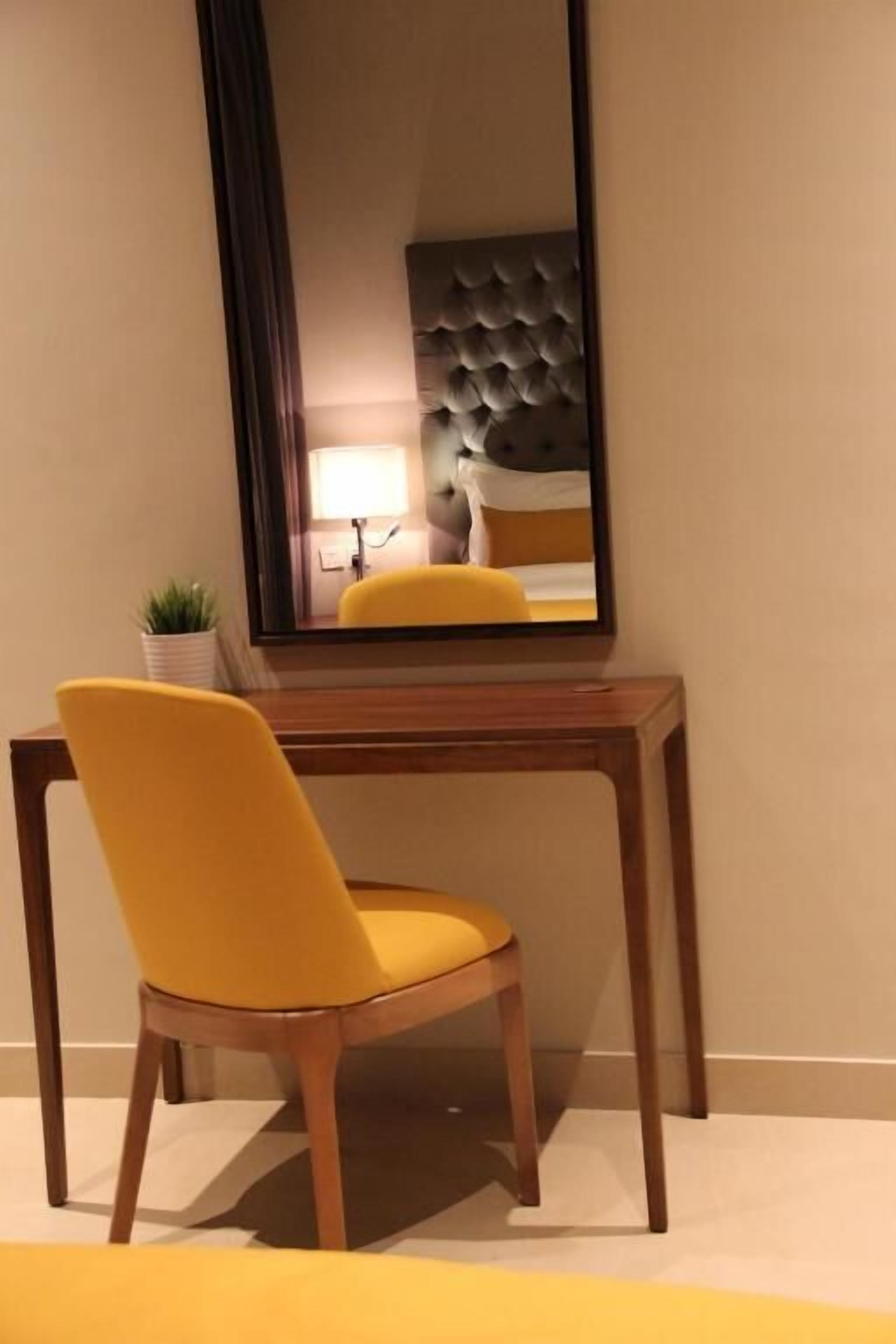 Ein Zimmer mit einem Holztisch und einem gelben Stuhl.