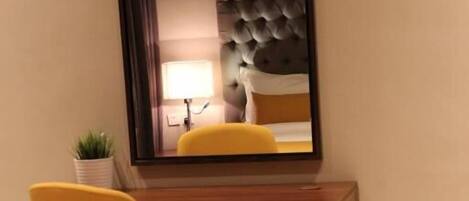 A room with a wooden desk and a yellow chair.