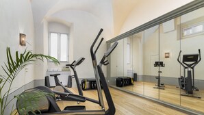 A gym with exercise equipment, a large mirror, and a potted plant. - Conte Jacopo - La Dimora degli Affreschi Florence (Florence)