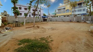 A residential area with houses, a dirt yard, and trees. - Swastik Hotel  (Deoghar)