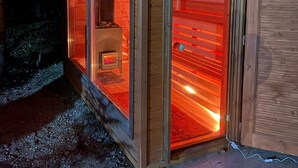 A wooden cabin with a glass door, a visible fireplace, and a metal door frame. - Private vacation home in the middle of the Harghita mountains surrounded by (Vărșag)