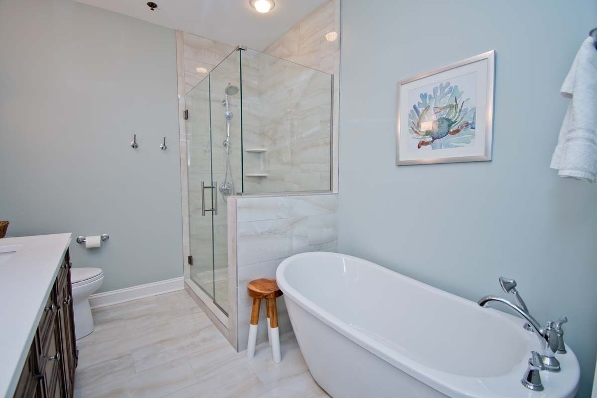 A modern bathroom with a freestanding bathtub, a glass shower enclosure, and a toilet.