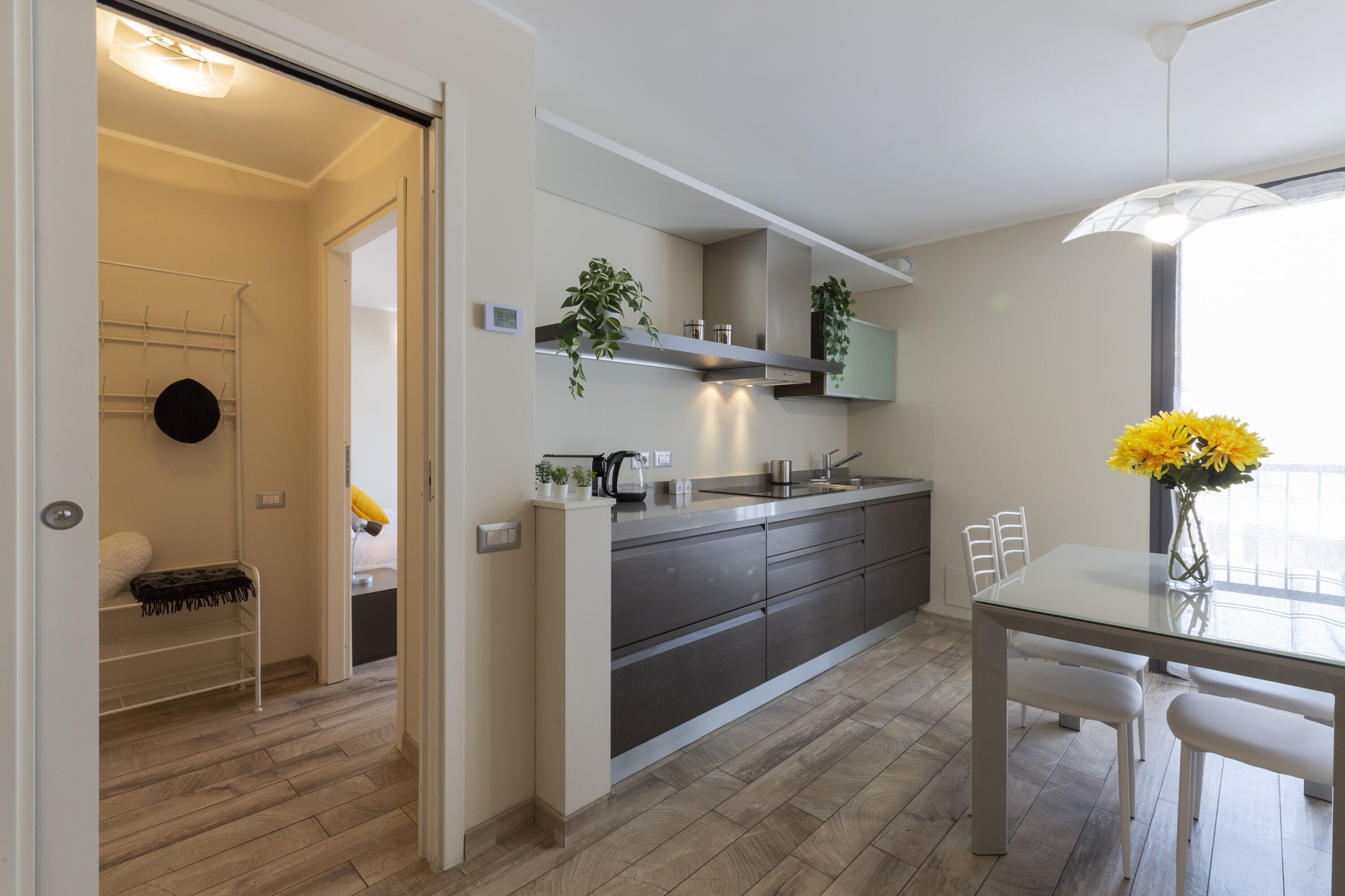 A modern kitchen with a central island, built-in appliances, and a dining area with a glass table and chairs.