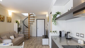 Een moderne keuken met een ingebouwde kookplaat, een koffiezetapparaat en een kleine koelkast.